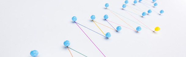 panoramisch shot van kleurrijke verbonden lijnen met pinnen, verbinding en leiderschap concept - Foto, afbeelding
