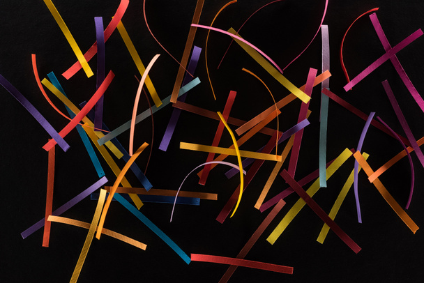 top view of multicolored abstract lines scattered isolated on black background, connection and communication concept - Фото, изображение