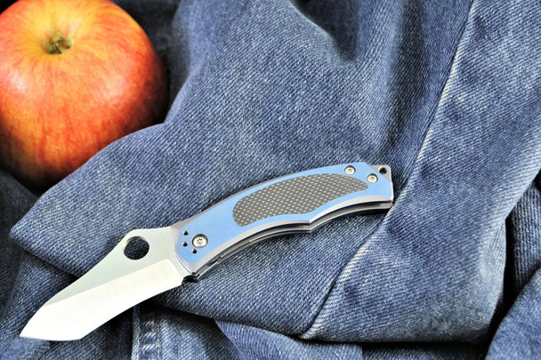 折り畳みナイフアップル有機ビタミングルメ健康的な製品のデニムの背景 - 写真・画像