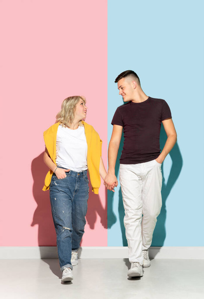 Young emotional man and woman on pink and blue background - Fotografie, Obrázek