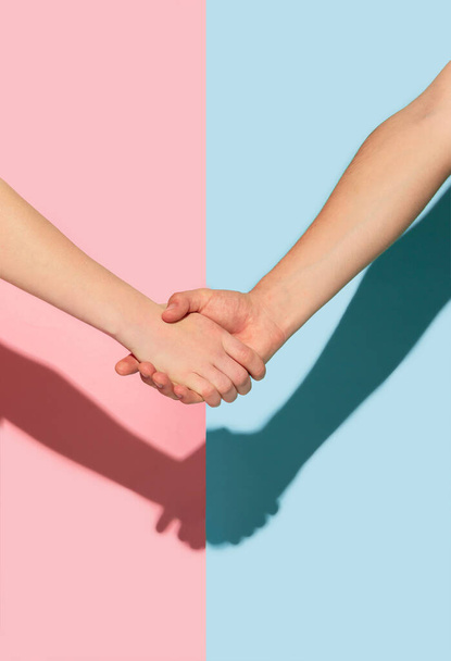 Female and male hands holding on pink and blue background - Foto, Imagem
