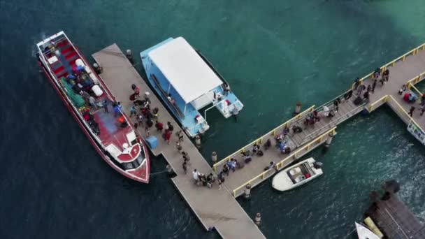 Top légi kilátás fából készült móló turistákkal megy a hajó fedélzetén nyugodt azúr óceán. Gili Air Island, Indonézia - Felvétel, videó