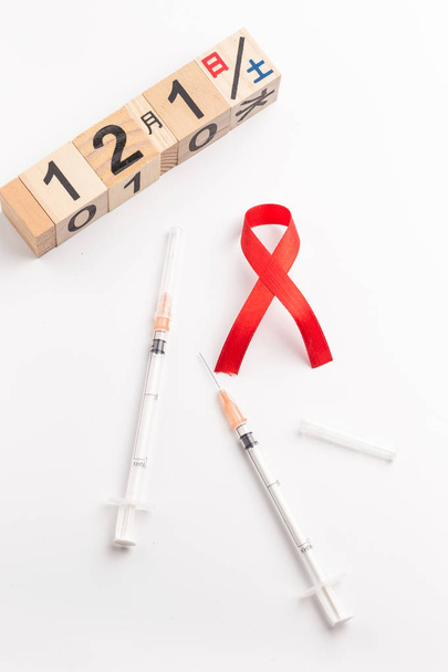 The red ribbon is an international symbol of HIV and AIDS awareness - Photo, Image