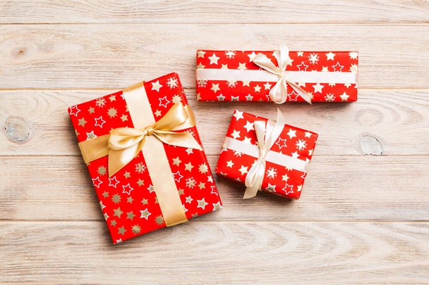 χάρτινο κουτί δώρου με χρωματιστή κορδέλα σε φόντο πορτοκαλί ξύλου. top view με αντίγραφο χώρου Χριστούγεννα έννοια διακοπών - Φωτογραφία, εικόνα