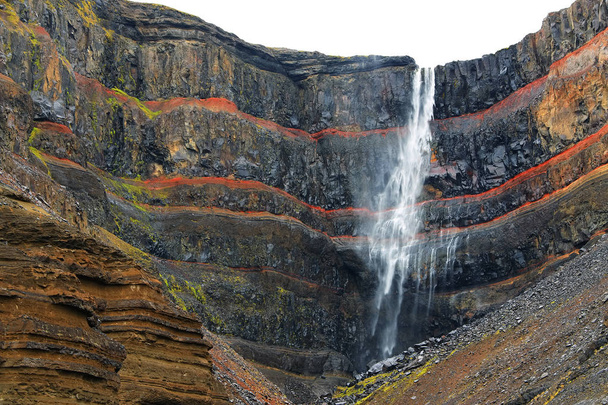 Cañón Hengifoss con la cascada Hengifoss, la tercera cascada más alta de Islandia está rodeada por estratos basálticos con capas rojas de arcilla entre las capas basálticas
 - Foto, imagen