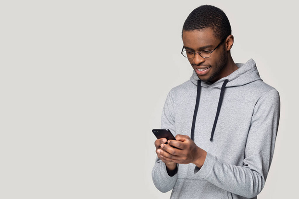 Smiling African American man using phone with copy space aside - Фото, изображение