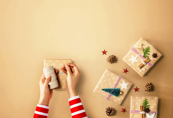 Person making Christmas gift boxes - Fotó, kép