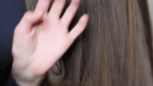 Using a comb to style long brown women's hair, close up video - Felvétel, videó