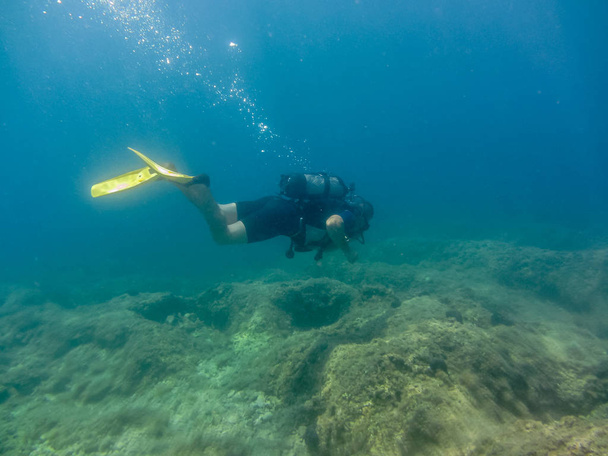 Nuori mies sukellusvarusteet uinti vedenalaisesti.Sukellus Joonianmerellä. Kreikka, Korfun loma kesällä
 - Valokuva, kuva
