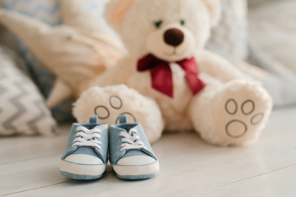 Blue sneakers for baby on the background of soft toys bears, close-up - Photo, Image