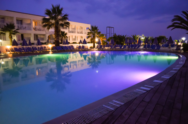  Piscine illuminée multicolore à l'hôtel resort pendant la nuit
 - Photo, image