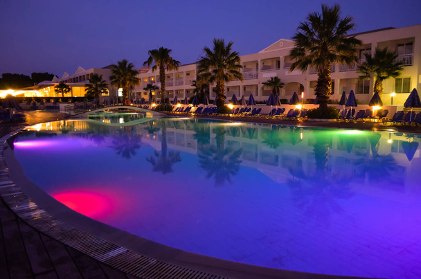  Vícebarevný osvětlený bazén v hotelovém resortu v Řecku, Korfu v noci. Letní dovolená . - Fotografie, Obrázek