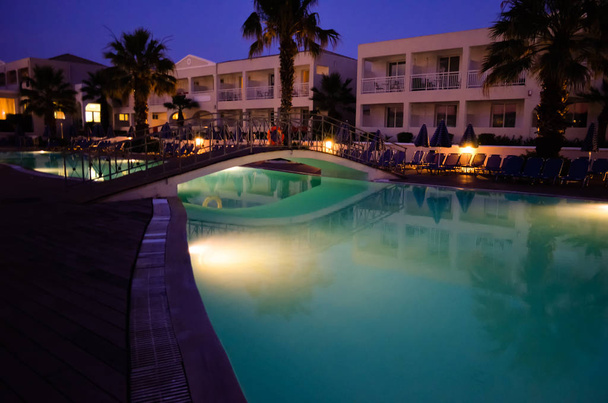  Багатокольоровий басейн з освітленими фарбами на готельному курорті в Греції, Корфу вночі. - Фото, зображення