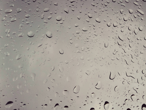 Краплі дощу, що покривають прозоре автомобільне скло
 - Фото, зображення
