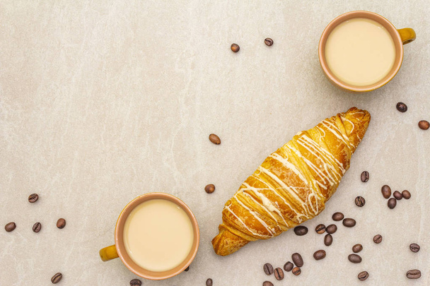 eine Tasse frischen Kaffee mit Croissant. das Konzept auf Steingrund mit gerösteten Kaffeebohnen, Draufsicht, flache Lage. - Foto, Bild