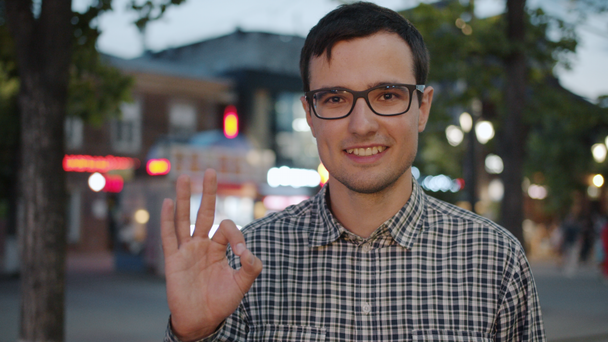 Πορτρέτο του χαρούμενου άντρα δείχνει Εντάξει χειρονομία χέρι και χαμογελώντας στην αστική δρόμο - Πλάνα, βίντεο