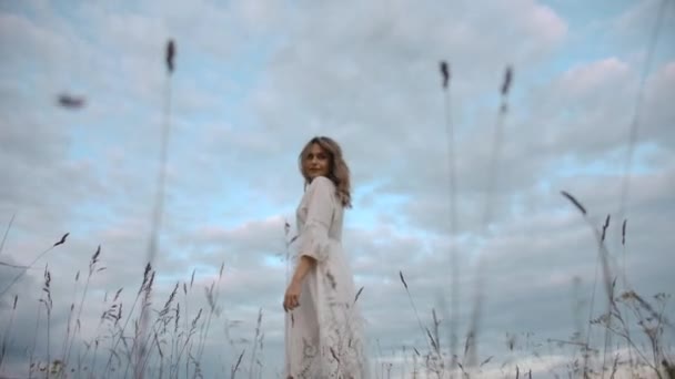 Elegáns romantikus nő fehér ruhában sétál a fűben - Felvétel, videó