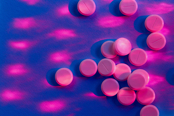 Pillole rosa su sfondo viola. Pillole, farmaci, salute e medicina concetto. Astratto sfondo colorato. Farmaci colorati, da vicino
. - Foto, immagini