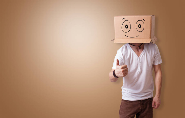 Ο άνθρωπος με το χαμογελαστό κεφάλι κουτί χαρτοκιβώτιο - Φωτογραφία, εικόνα
