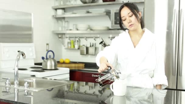 Asiática gir bebiendo té en la cocina
 - Imágenes, Vídeo