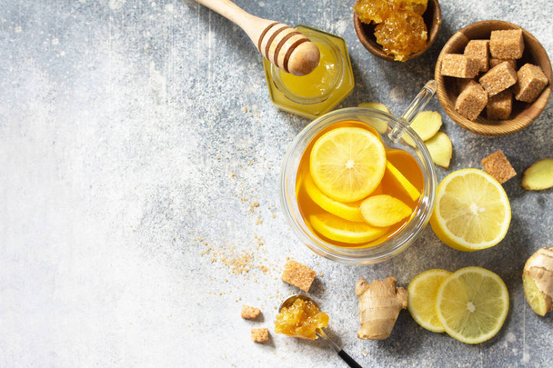Горячая чашка имбирного чая и ингредиентов - лимон, имбирь, соты
 - Фото, изображение