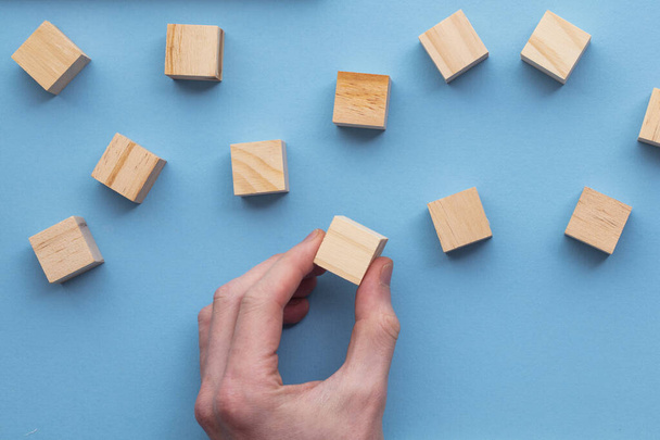 Hand choosing a wooden block from a set. Business choice concept - Foto, imagen