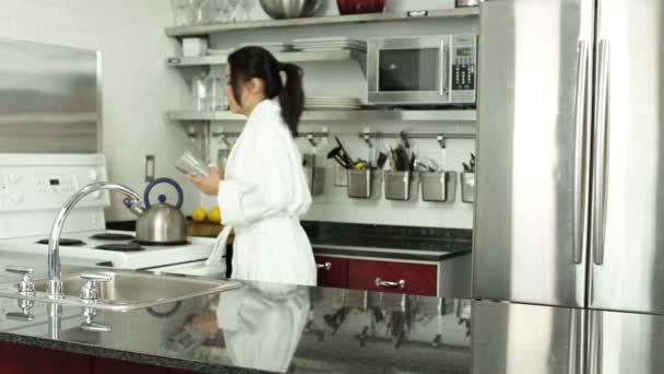 Азиатка, принимающая таблетки на кухне
 - Кадры, видео