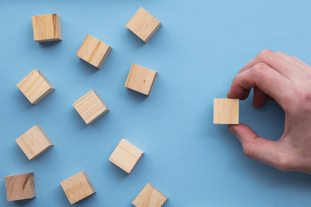 Hand choosing a wooden block from a set. Business choice concept - Фото, изображение