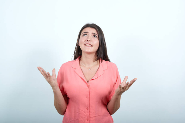 Young woman over white wall frustrated by a bad situation - Foto, imagen