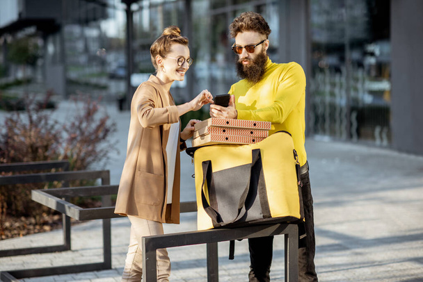 Чоловік доставляє піцу молодій жінці клієнту
 - Фото, зображення