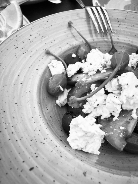 ízletes görög saláta feta sajttal, friss zöldségekkel és ízletes fűszerekkel - Fotó, kép