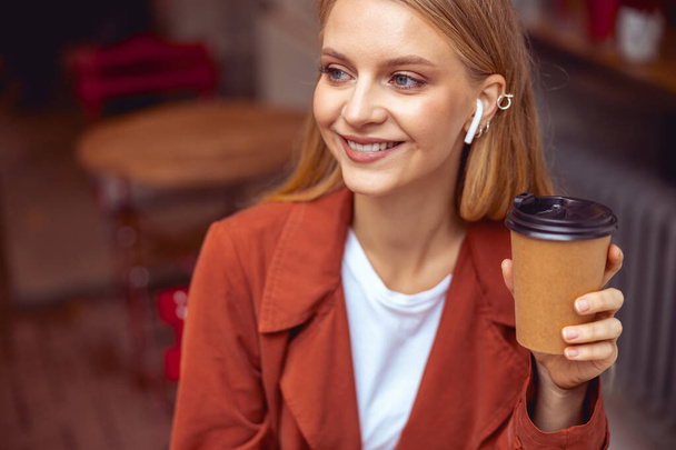 Smiling stylish beautiful woman in wireless earphones - Fotó, kép