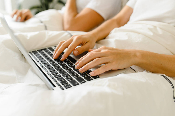 young couple using laptop together in bed  - Photo, image