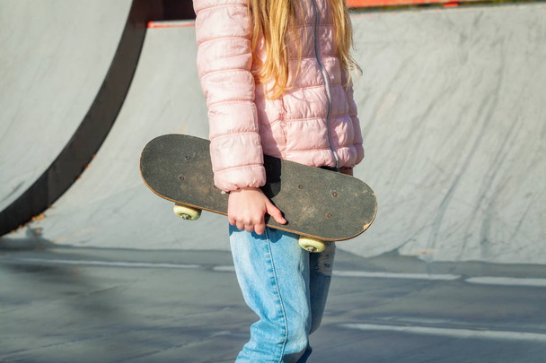 Маленькая девочка со скейтбордом на рампе
 - Фото, изображение