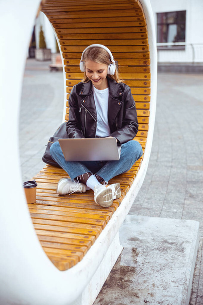 Stylish lady working on a laptop outdoors - Фото, зображення