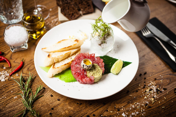 Тартар из тунца подается на тарелке в ресторане
 - Фото, изображение