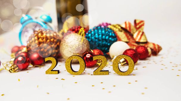 happy new 2020 year greeting card with glossy colorful christmas baubles and numbers isolated on white background   - 写真・画像