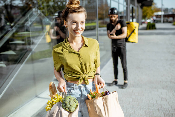 Woman with fresh products received from a courier - Foto, afbeelding