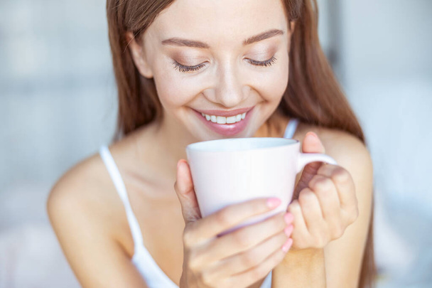 Portrait of charming brunette that looking into her cup - Photo, Image