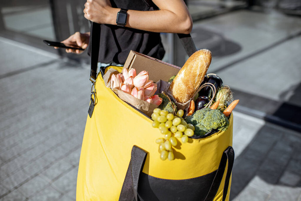 Kurierin liefert frische Lebensmittel mit Rucksack - Foto, Bild