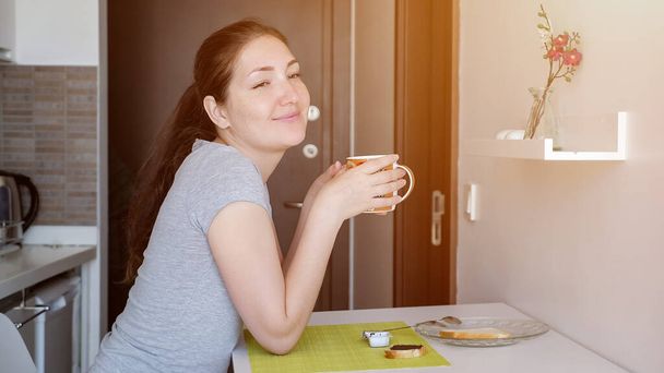 Young woman traveler is having a breakfast in hotel room. - Fotoğraf, Görsel