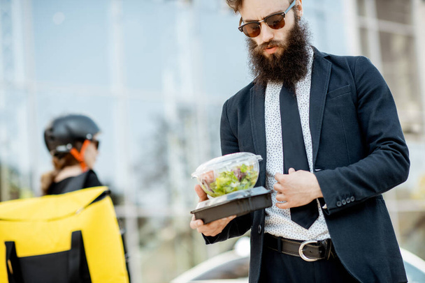 Trabajador de oficina con comida para llevar al aire libre
 - Foto, Imagen