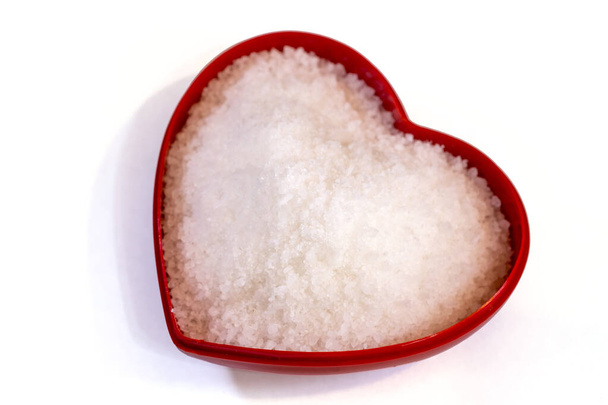 Сіль всередині контейнера у формі серця на білому тлі
 - Фото, зображення