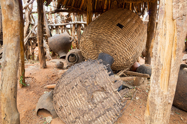 Varios cuencos de barro y viejas y usadas cestas de mimbre trenzadas bajo un cobertizo gris en un pueblo en Etiopía. Concepto de viaje y aventura
. - Foto, imagen