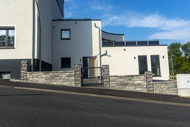 nouvelle maison avec une clôture en pierre contre le ciel bleu jour
 - Photo, image