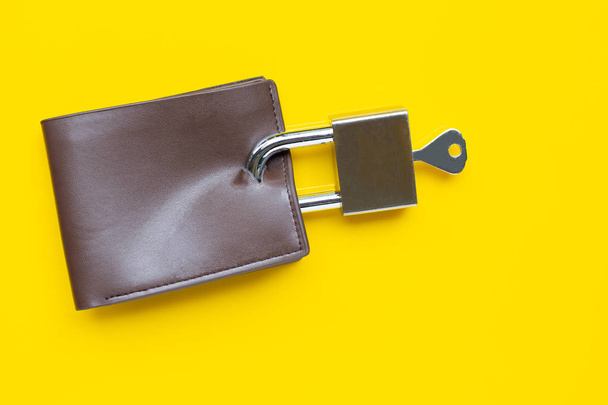 Wallet with padlock and key on yellow background. - Foto, immagini