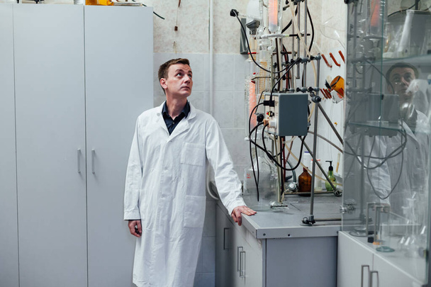 ученый-мужчина проводит химические эксперименты с жидкостями в медицинской лаборатории
 - Фото, изображение