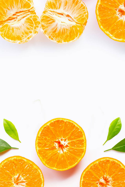 Рамка из апельсина с зелеными листьями, изолированными на белой спине
 - Фото, изображение