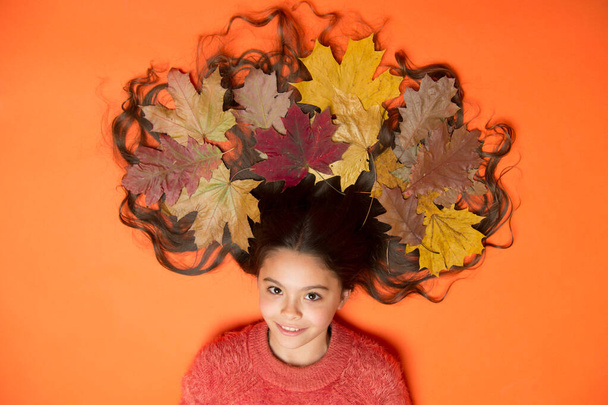 Deep conditioning treatment to combat static and tangles that come with fall. Fall season. Shampoo concept. Haircare tips add to fall routine. Little girl gorgeous long hair and fallen maple leaves - Φωτογραφία, εικόνα