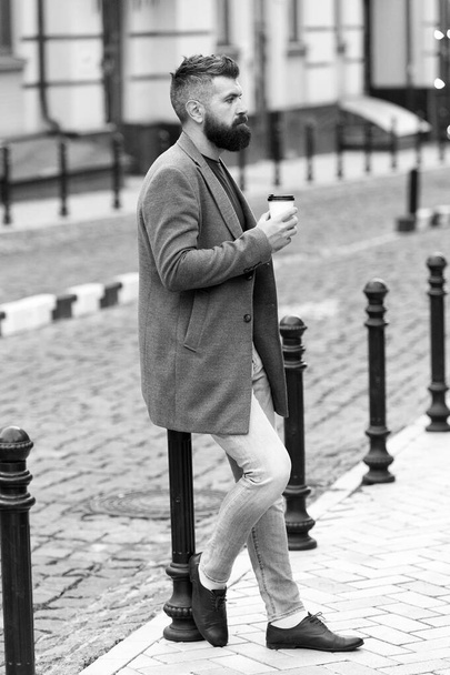 Waiting for someone in street. Man bearded hipster drink coffee paper cup. Businessman well groomed enjoy coffee break outdoors urban background. Enjoying coffee time. Walk and enjoy fresh hot coffee - Photo, Image